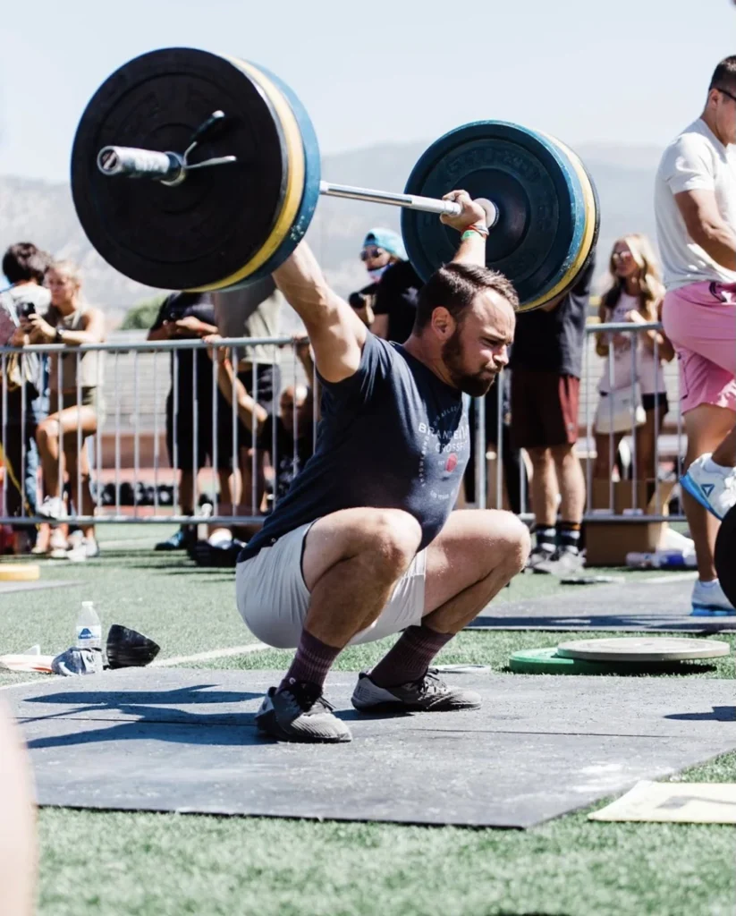 Man doing a squat snatch at an outdoor event