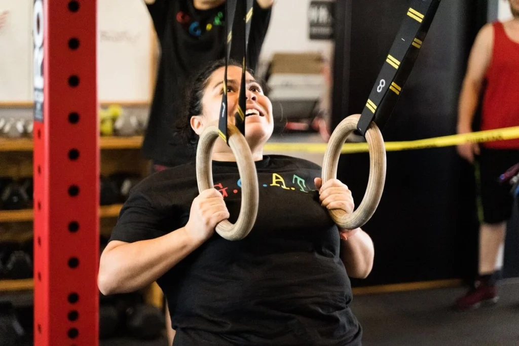Female using Rings in a gym